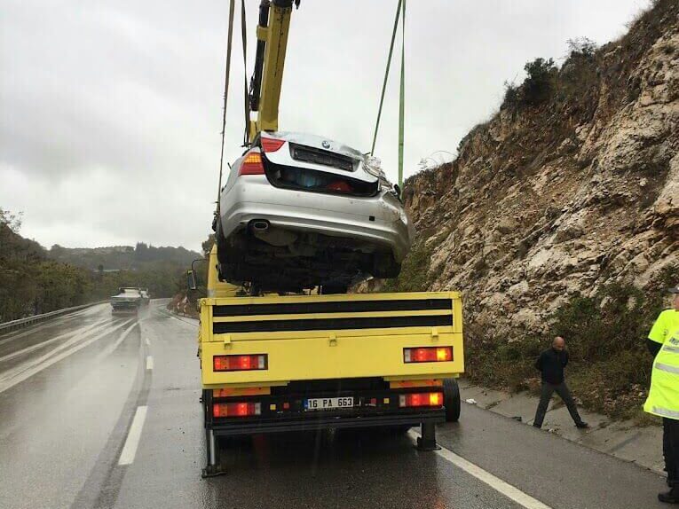 İnegöl'de kazalı bir aracın olay yerinden kaldırılıp nakledilmesi.